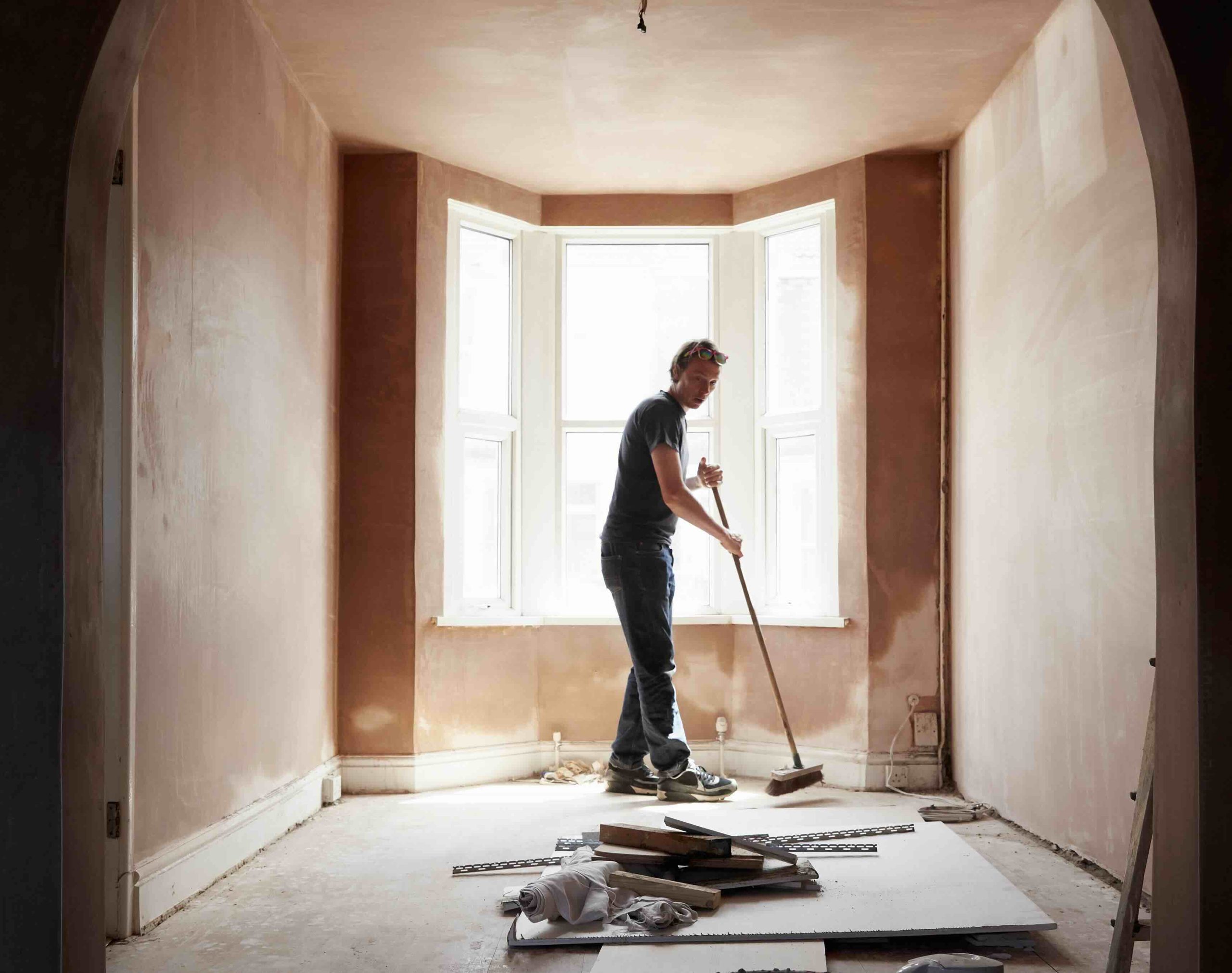 A photo of a builder cleaning up during a home renovation project.
