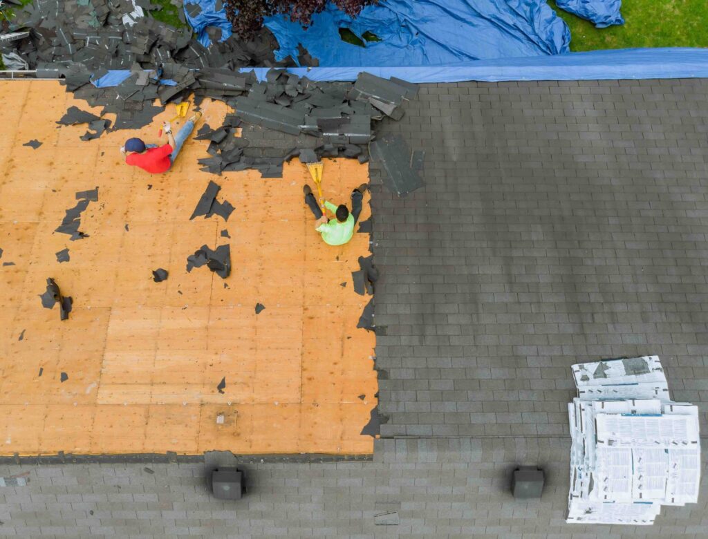 A photo of a roof repair project in progress, along with the waste that a dumpster rental can help dispose of.